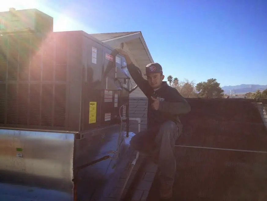 HVAC technician performing Air Duct Cleaning on a rooftop unit in Salisbury